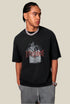 Male model in black Yesskary tee looks to the side with hands in pockets.