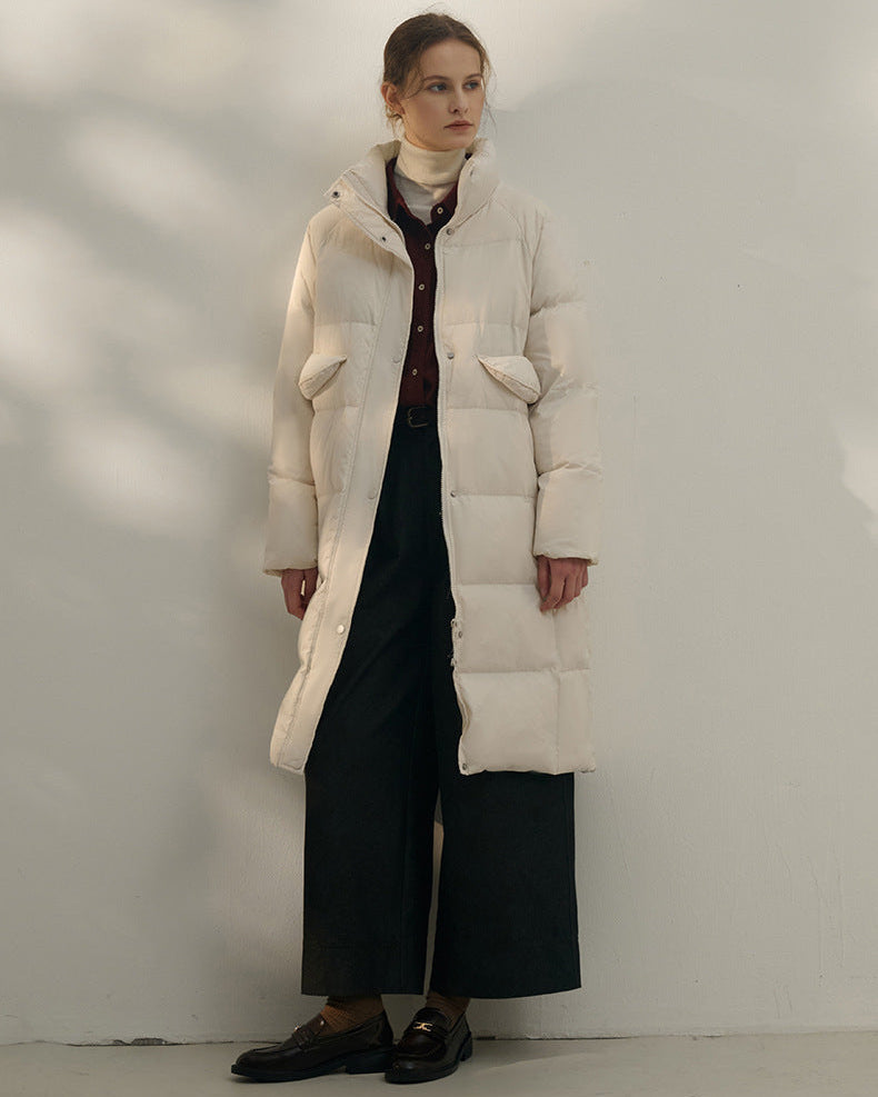 Woman wearing long cream puffer coat layered over burgundy top and wide-leg pants, ZINNTRA women’s FW25 collection cover