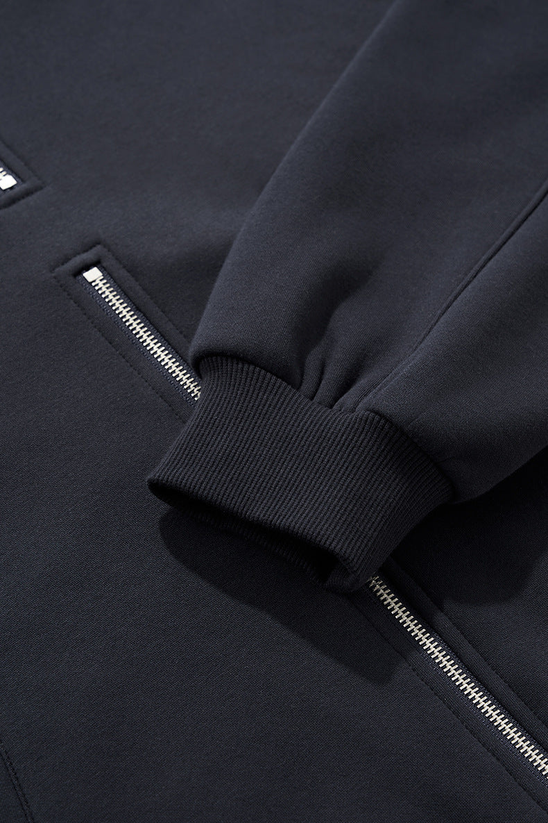 Dark gray zip hoodie on female model, hands in pockets, relaxed hem